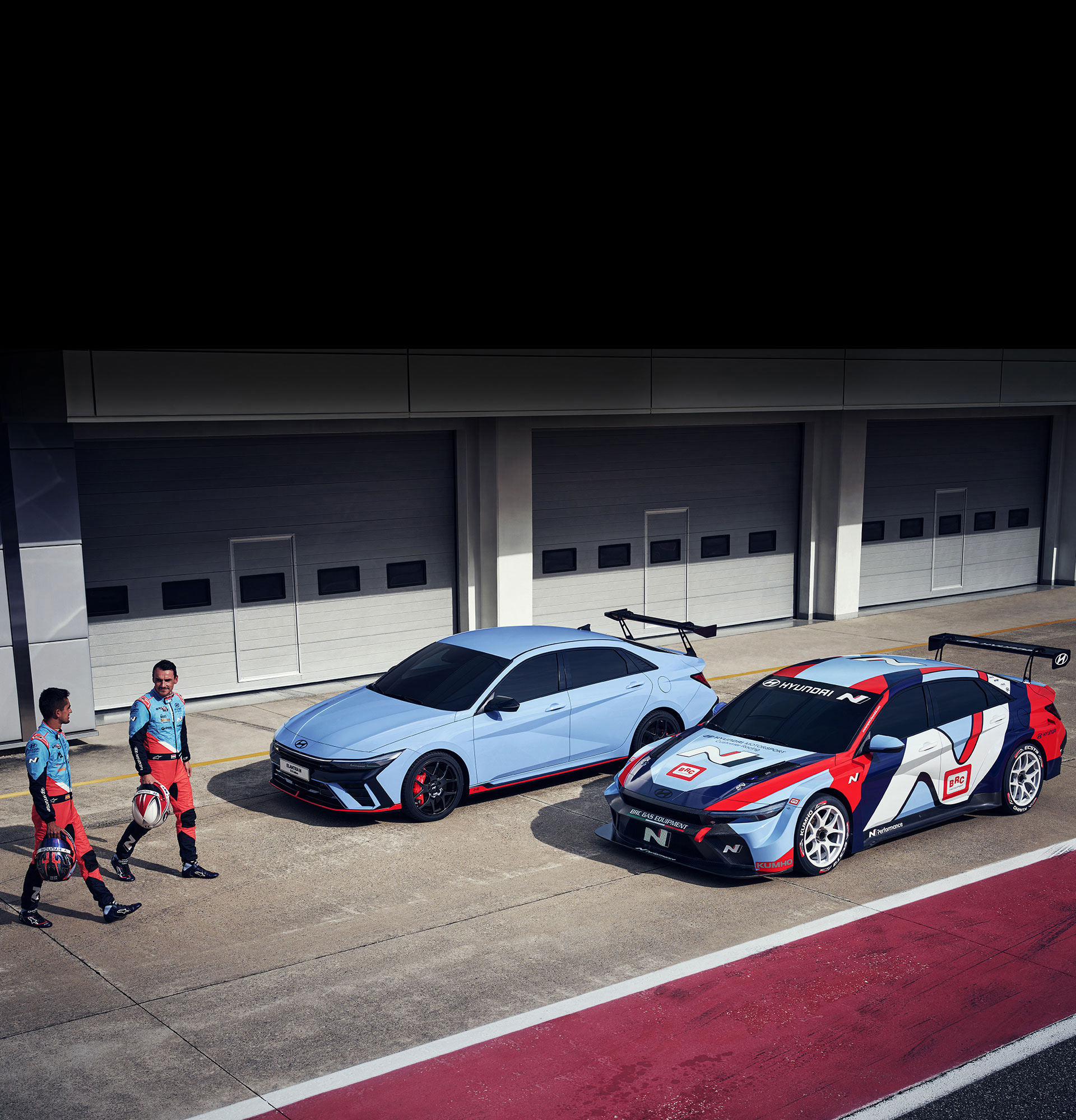 There are two ELANTRA N TCR edition vehicles side by side, and the vehicle on the right is equipped with a ELANTRA TCR edition decal. A photo of two players walking in front of cars standing side by side.