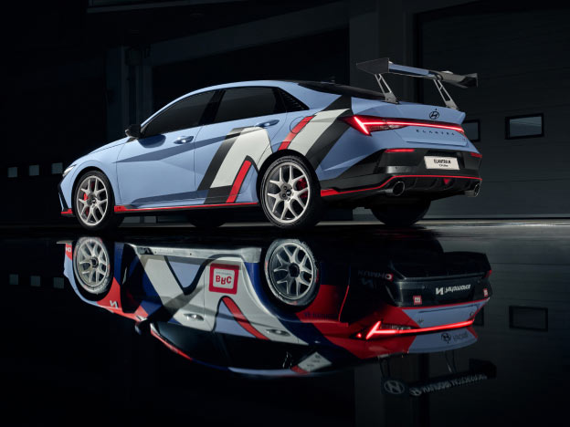 A photo showing the left side of the Elantra N TCR Edition, and the Elantra TCR Edition decal installed on the car reflected like a mirror on the floor.