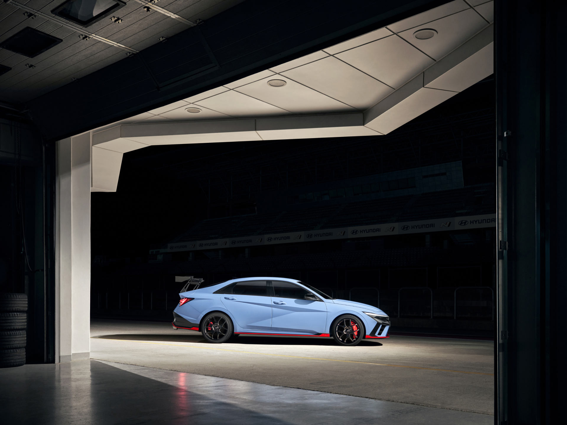 The ELANTRA N TCR Edition stands on a circuit in the dark.